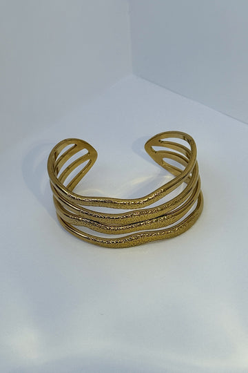 Pulseira aberta em aço dourado com textura ondulada