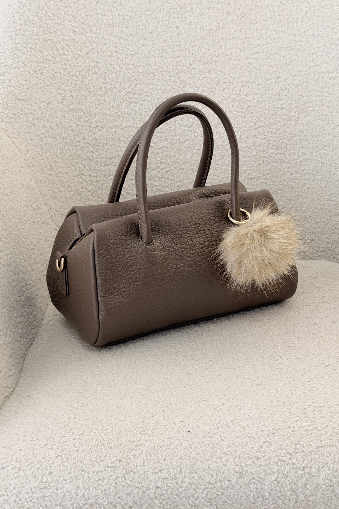 Bolsa cilíndrica com pom-pom