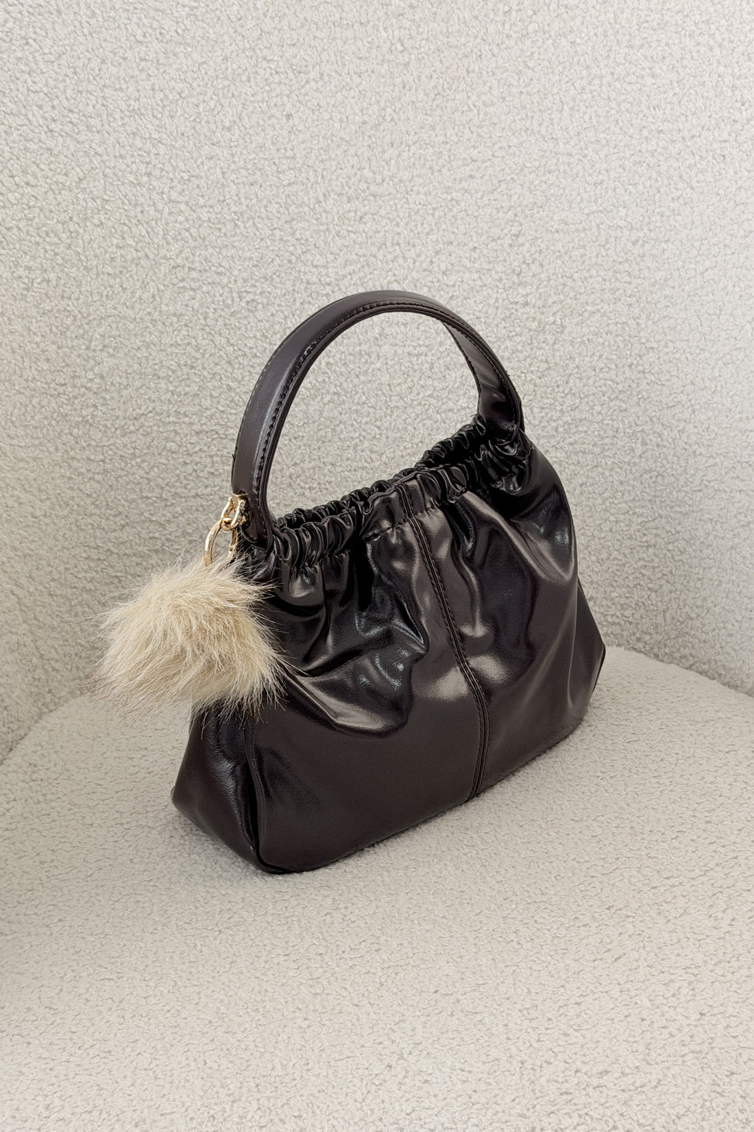 Bolsa de mão brilhante com pompom